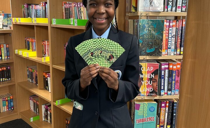 Carmel College student showing their printed bookmark, to commemorate World Book Day
