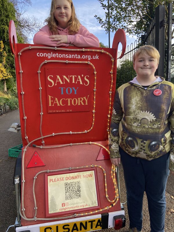 Image of William and Amber Volunteer with Santa!