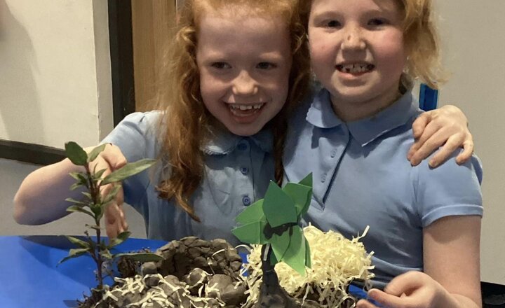 Year 3 pupils showing their clay Stone Age house 