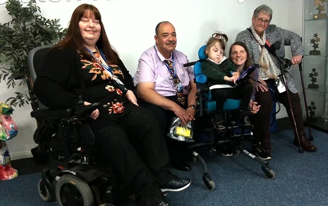 Photograph showing adults with a child holding her new iPad
