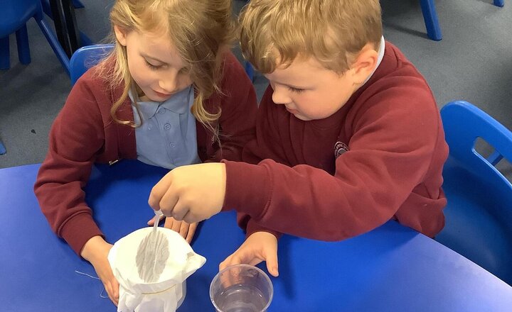 Image of We're deep into our Materials unit! Last week, the children conducted an investigation to test waterproof materials. They made a prediction, covered containers, and dripped water on top to see which material kept the object dry.