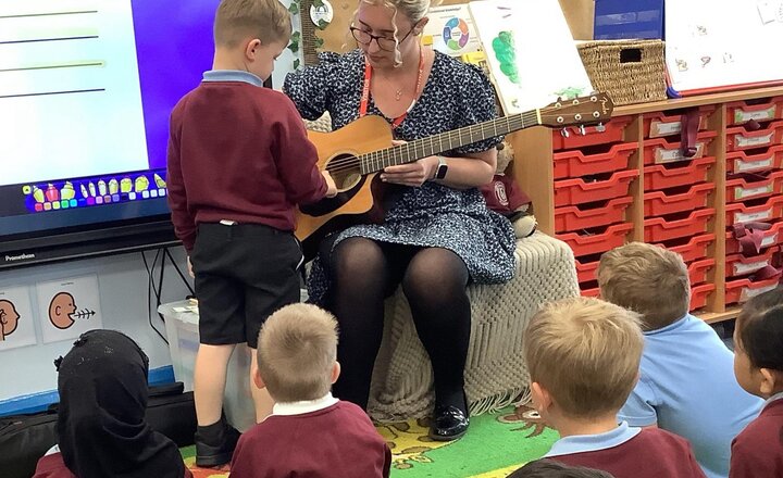 Image of Miss Abbotts brought in her guitar today and we enjoyed learning about it and singing some hymns.