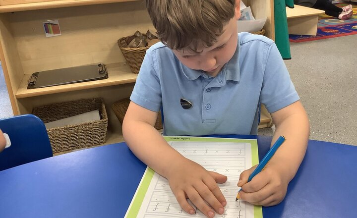 Image of Working hard on our handwriting in provision.
