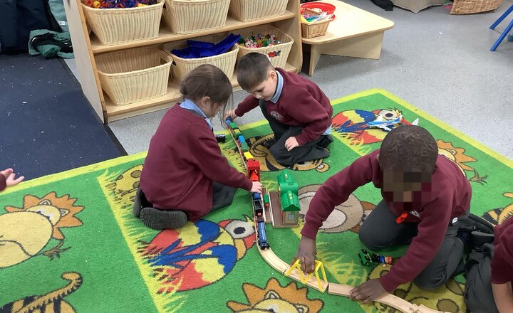 Image of Working hard together as a team, making a very long train track in provision!
