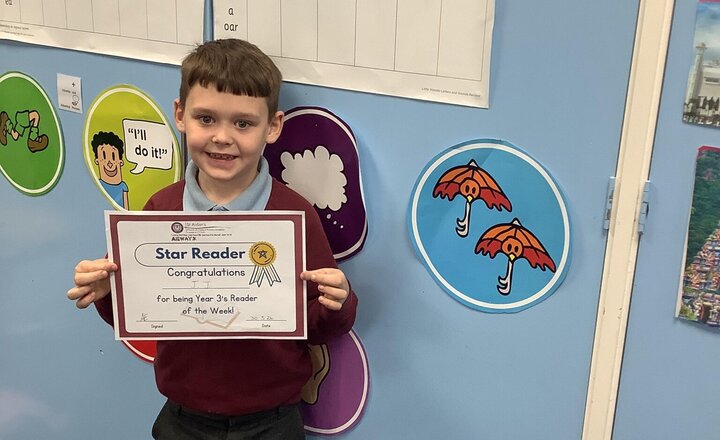 Image of This weeks star reader is JJ.  He is also demonstrating the meanings behind the cross that we made in nurture club.