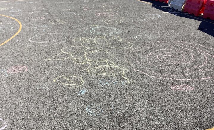 Image of Today in Art, we have been creating spirals using another different medium. We used chalk on the playground in the sunshine. They did a super job!