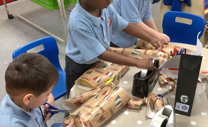 Image of Busy wrapping presents to go under our Christmas tree! (Working on our fine motor skills)