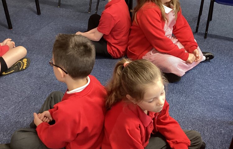 Image of Class 2 starting the day with some mindfulness back to back breathing.