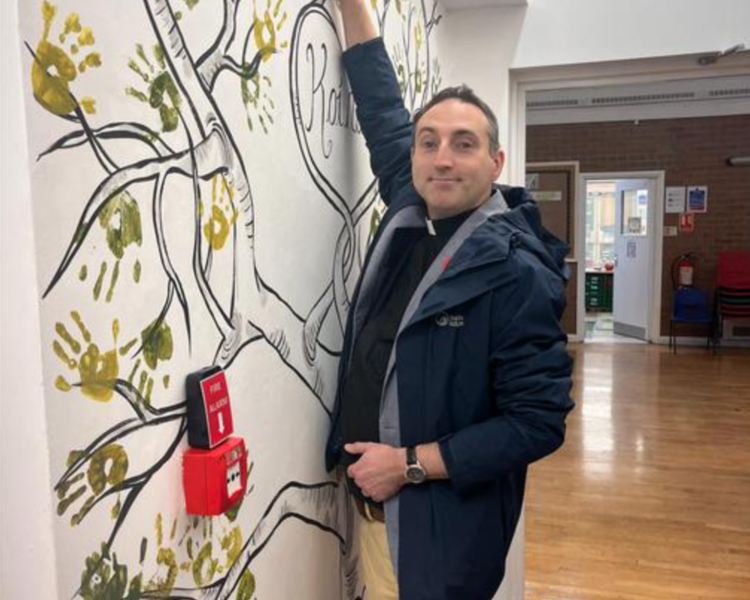 Image of Revd John adding his handprint to our Koinonia Tree