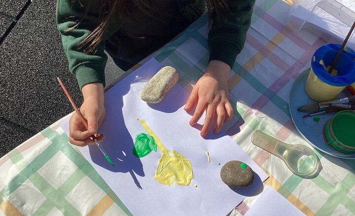 Reception pupil holding up their painted flower to celebrate the arrival of Spring