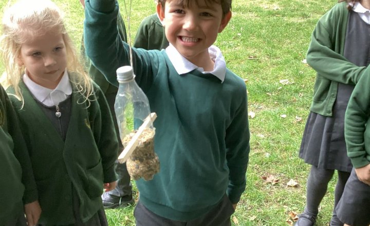 St Augustine's pupil holding up their recycled bottles which has been transformed into a bird feeder!