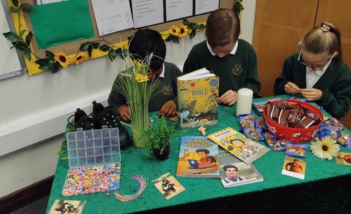Year 6 celebrate the Feast Day of St Carlo Acutis by making friendship bracelets for their Reception buddies