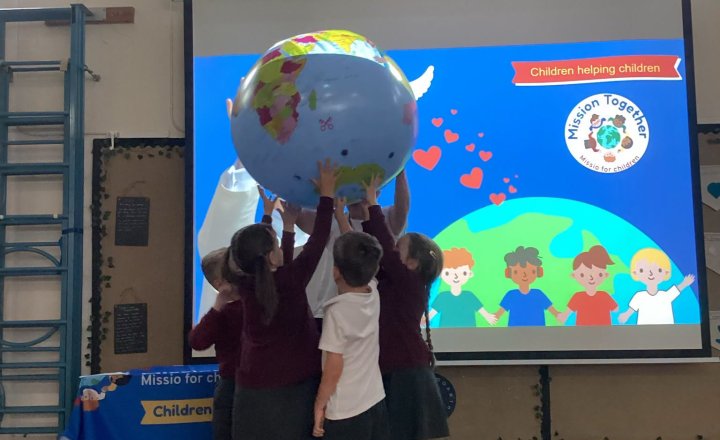 St Bede's pupils holding up a large inflatable earth, during a Mission Together introduction from Maria