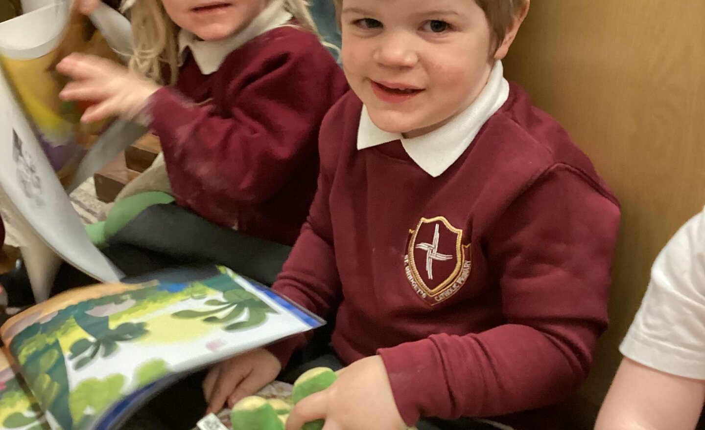 Image of Sharing a story with a teddy in Nursery