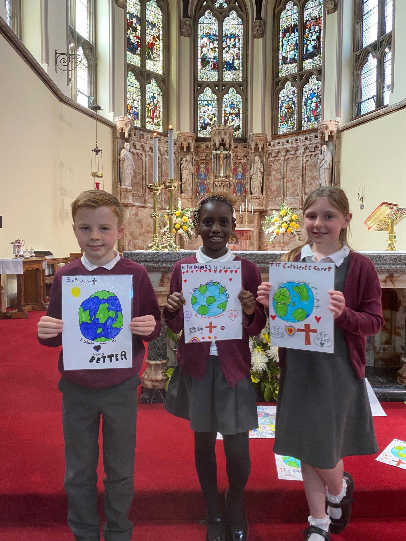 Three St Cuthbert's pupils, attending the special Mass in honour of St Cuthbert's Care