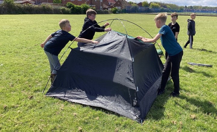 Year 4 pupils developing their outdoor skills through putting up a tent together