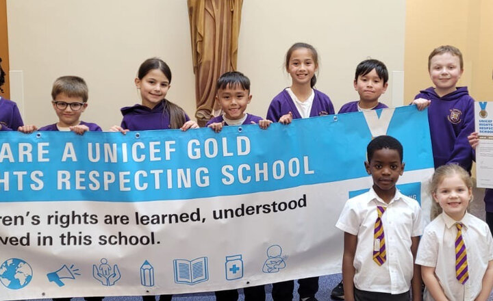 Group of school pupils holding the gold award banner