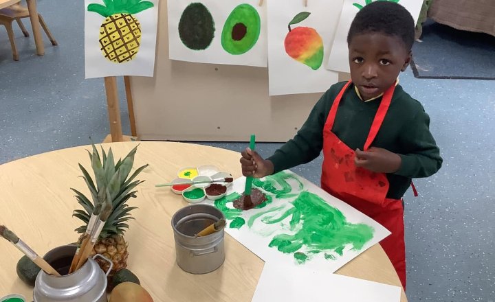 Pupils painting bright fruits inspired by the story of Handa's Surprise