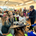 Image of SEA Students are served tea & cake at Ashton's new food bank by the Mayor of Manchester, Andy Burnham!
