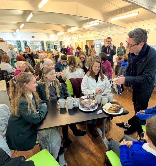 Image of SEA Students are served tea & cake at Ashton's new food bank by the Mayor of Manchester, Andy Burnham!